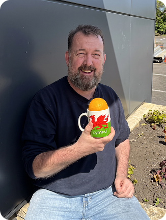 Team member smiling with a gift at his desk